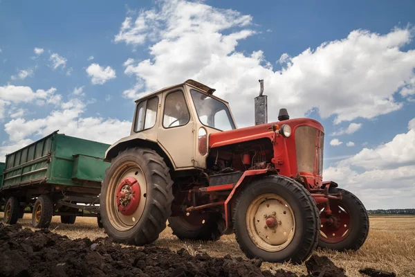 Vieux tracteur dans le champ, contre un ciel nuageux — Photo