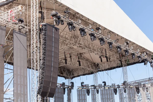 Outdoor concertpodium met verlichting en geluidsapparatuur voor de uitvoering. Stage constructie. Installatie scène voor concert — Stockfoto