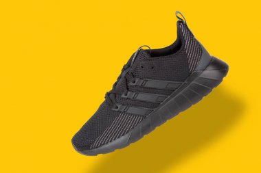 Varna , Bulgaristan - 25 Mart 2019 : Adidas Questar Flow spor ayakkabı, sarı arka plan üzerinde. Ürün çekimi. Adidas, spor ayakkabı, giyim ve aksesuar tasarlayan ve üreten bir Alman şirketidir.
