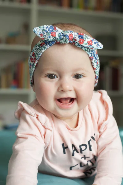 Bayi perempuan lucu dengan pita rambut, tersenyum, tertawa. Manis anak bersenang-senang di rumah, konsep kebahagiaan . — Stok Foto