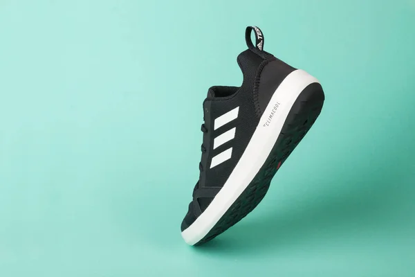 Varna, Bulgarije-3 mei 2019: Adidas Terrex CC boot sportschoen, op groene achtergrond. Product opname. Adidas is een Duitse onderneming die sportschoenen, kleding en accessoires ontwerpt en vervaardigt — Stockfoto