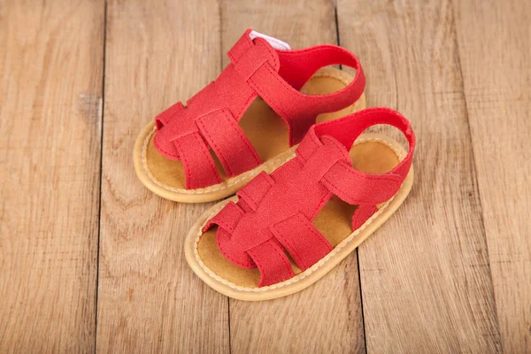 Par de sapatos de sandálias de bebê no fundo de madeira — Fotografia de Stock