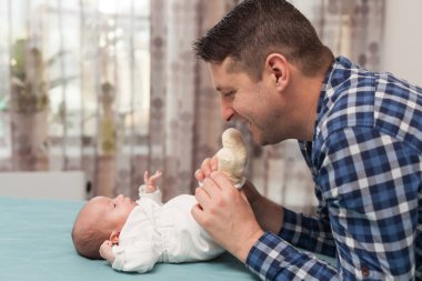 Mutlu baba evde küçük bebekle oynuyor. Aile, babalık kavramı 