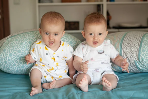 Evde yatakta gülüyor mutlu kardeşçe ikizler... Evde aile. — Stok fotoğraf