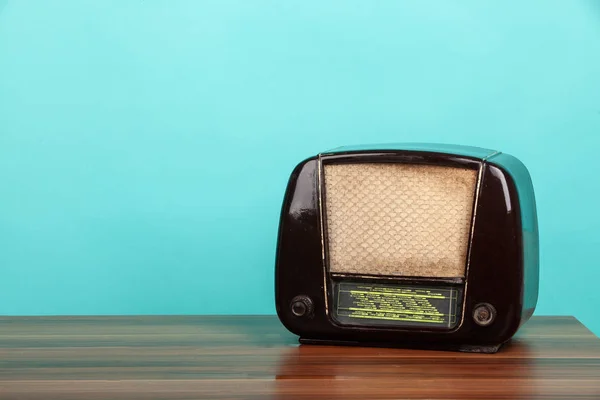 Old radio on table in front of green background. Vintage style photo — Stock Photo, Image