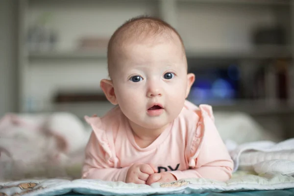 Ritratto di un bambino affascinante disteso sullo stomaco. Mattinata in famiglia a casa. Tempo di pancia — Foto Stock