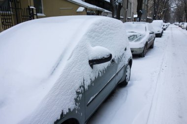 Kar fırtınasından sonra şehir caddesi. Karla kaplı arabalar.