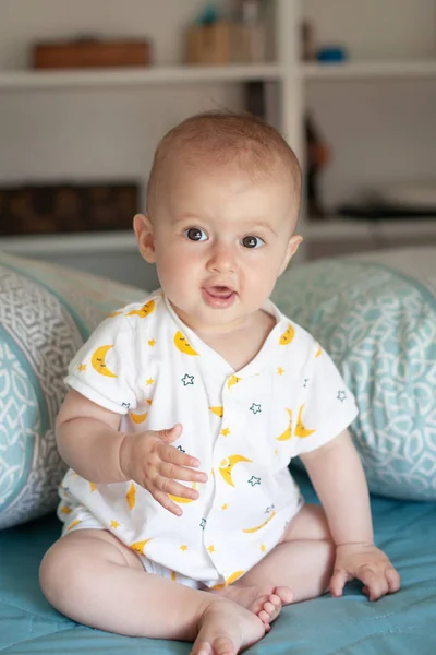 Portré egy aranyos mosolygó baba pizsama a hálószobában. Családi reggel otthon. — Stock Fotó