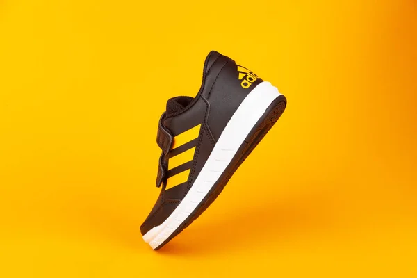 Varna, Bulgarije-13 augustus 2019: Adidas Alta sport schoen, op gele achtergrond. Product opname. Adidas is een Duitse onderneming die sportschoenen, kleding en accessoires ontwerpt en vervaardigt — Stockfoto