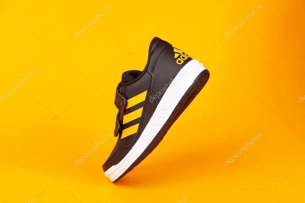 Varna , Bulgaria - AUGUST 13, 2019 : ADIDAS ALTA SPORT  shoe, on yellow background. Product shot. Adidas is a German corporation that designs and manufactures sports shoes, clothing and accessories
