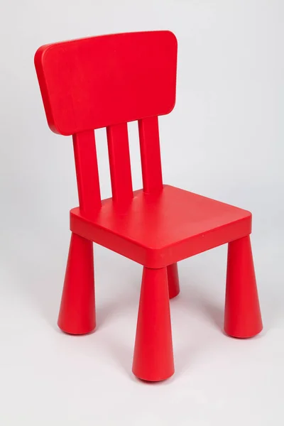 Small red plastic children 's chair — стоковое фото