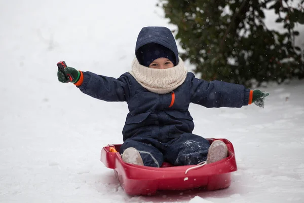 Felice bambino sulla sua slitta nella neve invernale — Foto Stock