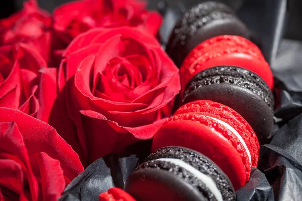 Rosas rojas y macarrones negros y rojos. Antecedentes para el día de San Valentín y la mujer. Decoración de boda —  Fotos de Stock