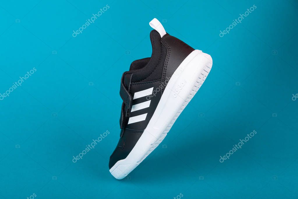 Varna , Bulgaria - AUGUST 13, 2019 : ADIDAS Tensauru sport shoe, on blue background. Product shot. Adidas is a German corporation that designs and manufactures sports shoes, clothing and accessories