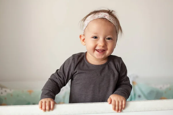 Cute baby laughing, standing in crib. Happy baby. Baby emotions. Baby smile. — Stock Photo, Image
