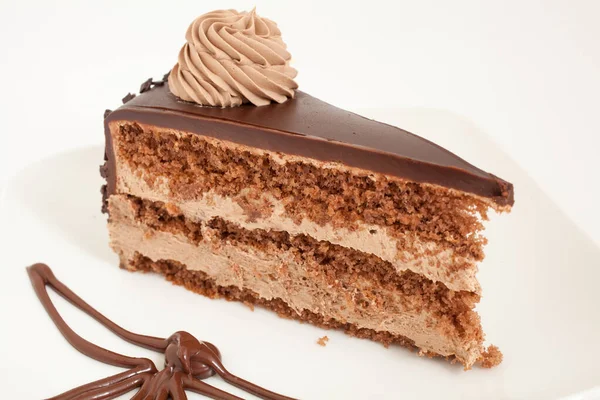 Slice of chocolate cake with decoration on white plate — Stock Photo, Image