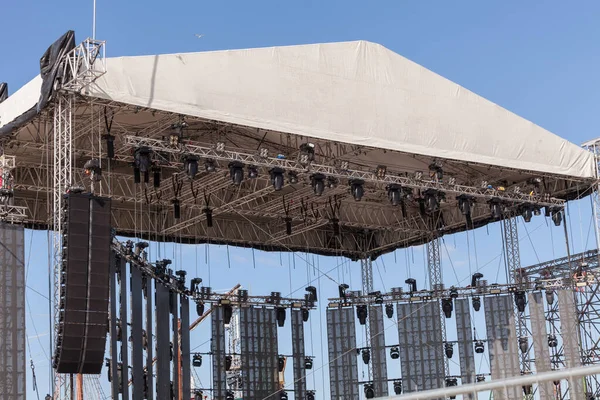 Outdoor concert stage with lighting equipment before performance. Stage construction. Installation scene for concert
