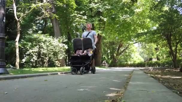 Pai Com Filhos Carrinho Duplo Num Parque Homem Empurrando Gêmeos — Vídeo de Stock