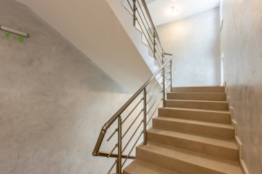 Katlar arasında modern merdiven. Modern binada metal raylı merdivenler