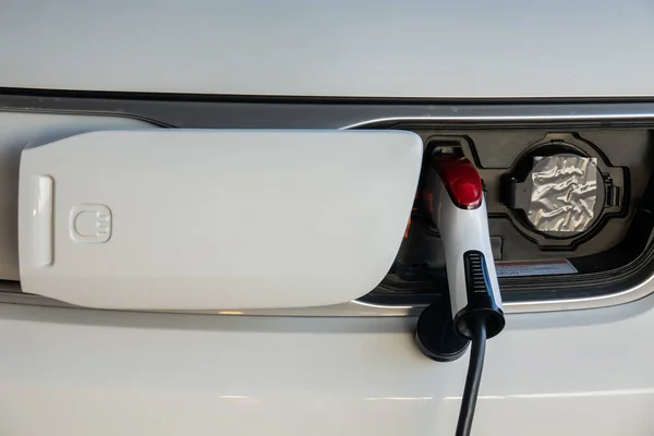 Close up charging an electric car battery. Electric car at charging station with the power cable supply plugged in