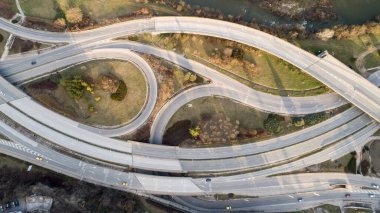 Top down view of highway multi level junction road with moving cars. View of traffic jam passing through city center clipart