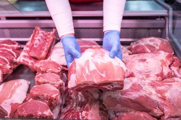 肉片を持つ肉屋の手の閉鎖 スーパーマーケットで新鮮な肉を提供 — ストック写真