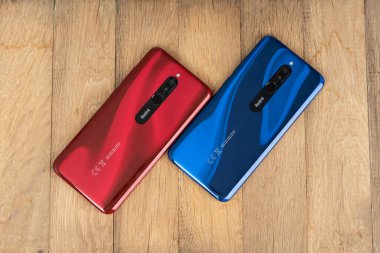 Varna, Nulgaria - 16 Mayıs 2020: Yakut kırmızısı ve Sapphire mavisi ahşap zemin üzerinde Redmi 8 akıllı telefonlarının arkası. Redmi, Çinli elektronik şirketi Xiaomi 'ye ait bir markadır..