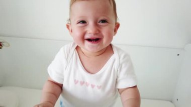 Sevimli bebek gülüyor ve eğleniyor, beşiğinde duruyor. Mutlu bebek. Bebek duyguları. Bebek gülümsemesi.