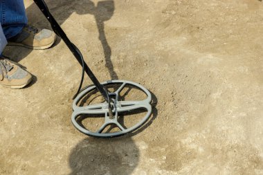 Arkeolojik kazı. Metal dedektörü. Metal detektörlü bir adam, arkeolojik hazineler arıyor.