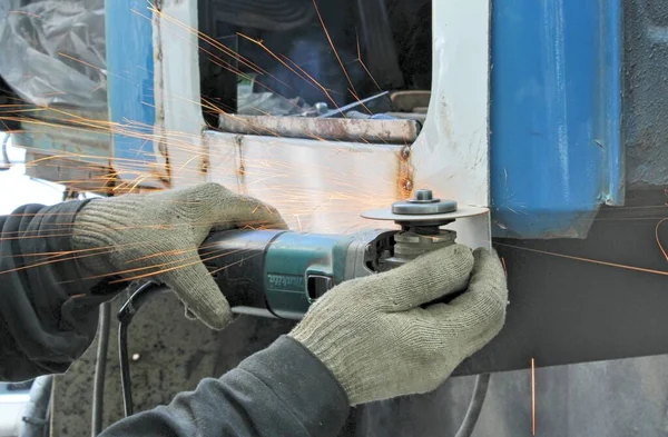 El trabajador corta el metal del coche por la rectificadora angular —  Fotos de Stock