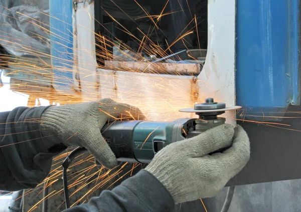 El trabajador corta el metal del coche por la rectificadora angular —  Fotos de Stock