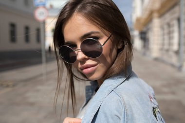 Güneş gözlüklü genç bir kadının portresi..
