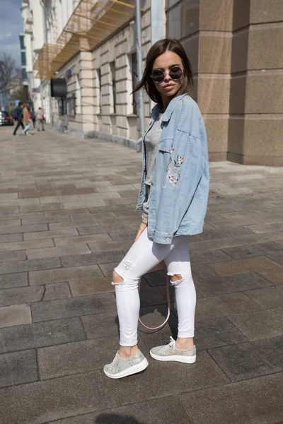 Молодая модная женщина в солнечных очках ходит по улице . — стоковое фото