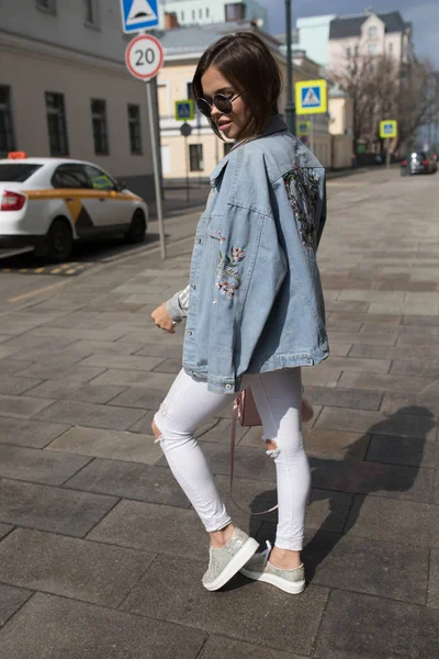 Jonge trendy vrouw in zonnebril wandelen langs de straat. — Stockfoto