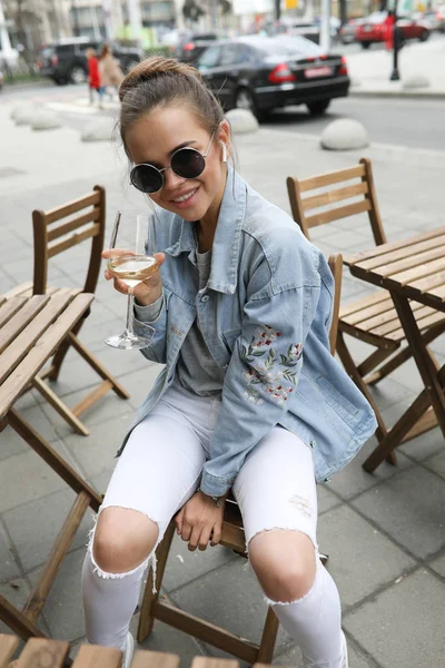 Красивая девушка пьет белое вино в уличном кафе . — стоковое фото