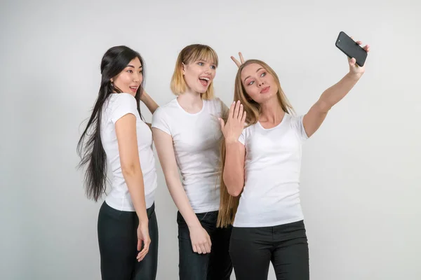 Hermosas chicas divertidas hacen selfie. Chicas en camisetas blancas . — Foto de Stock