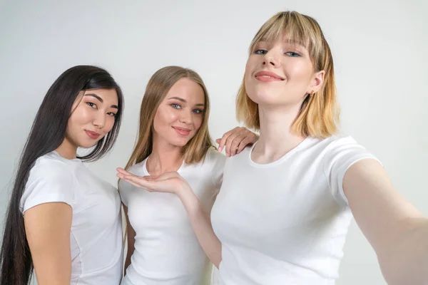 Hermosas chicas divertidas hacen selfie. Chicas en camisetas blancas . — Foto de Stock