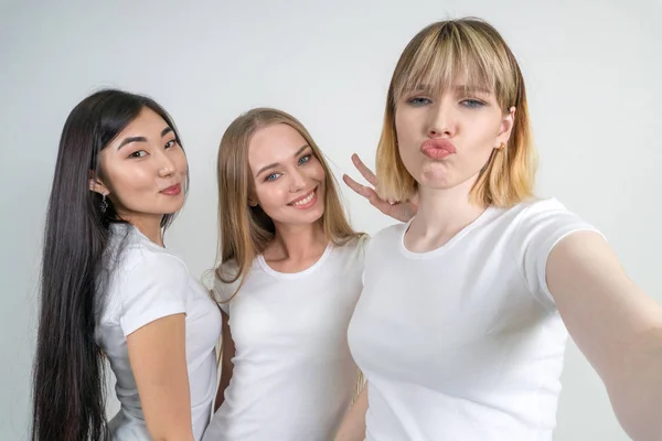 Hermosas chicas divertidas hacen selfie. Chicas en camisetas blancas . — Foto de Stock