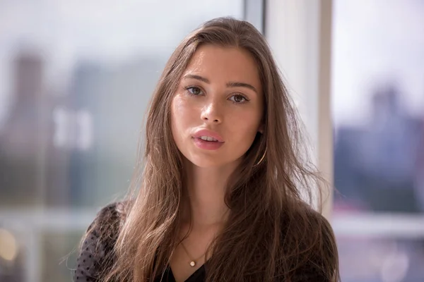 Portrait of an attractive girl on a window background. — Stock Photo, Image