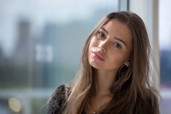 Portrait of an attractive girl on a window background. — Stock Photo, Image