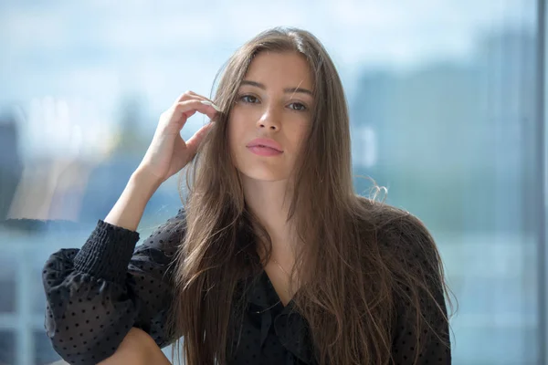 Portrait of an attractive girl on a window background. — Stock Photo, Image