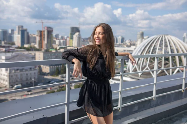 Giovane donna in piedi sulla terrazza con vista sulla città . — Foto Stock