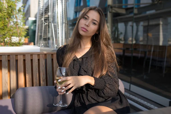 ワインのグラスとレストランのテラスに座っていた若い女性. — ストック写真