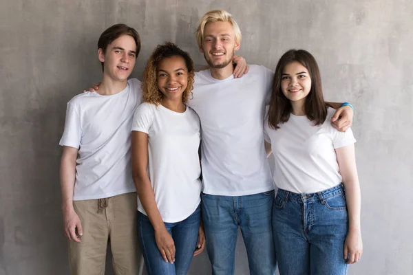 Multiraciale groep van vrienden in witte t-shirts op grijze achtergrond. — Stockfoto