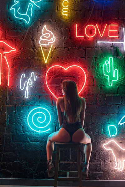 Сексуальная молодая женщина в красивом кружевном белье на фоне неоновых ламп . — стоковое фото