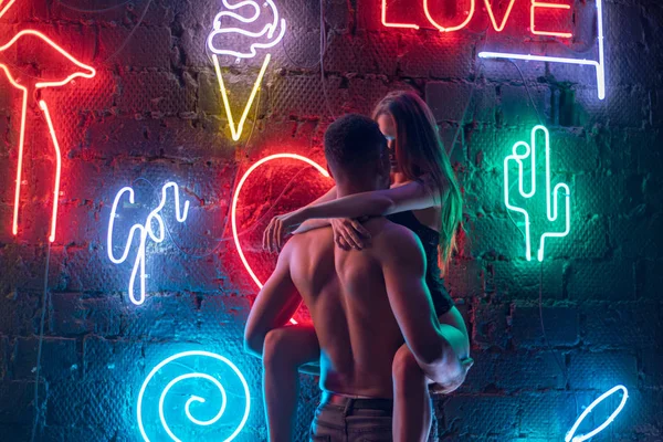 Neon lambaları arka plan üzerinde öpüşme tutkulu çift.