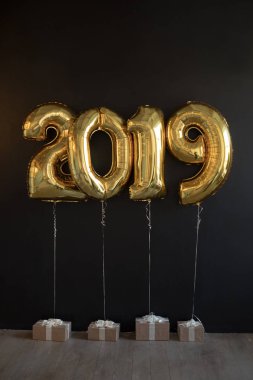 Siyah arka plan üzerine yeni yıl için altın balon işareti 2019 yapılan.