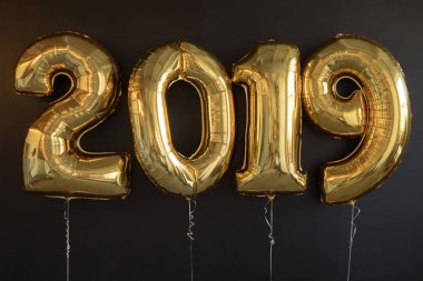 Siyah arka plan üzerine yeni yıl için altın balon işareti 2019 yapılan.