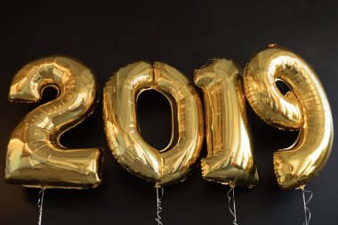 Siyah arka plan üzerine yeni yıl için altın balon işareti 2019 yapılan.