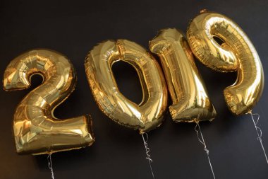 Siyah arka plan üzerine yeni yıl için altın balon işareti 2019 yapılan.